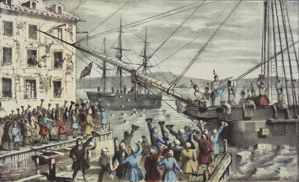 A colored 1846 lithograph of the Boston Tea Party: colonists on a Boston wharf and aboard a moored ship tipping crates of tea into the harbor while a crowd cheers from the dock